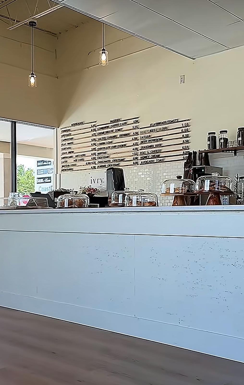 The ivry. service counter with pastry domes and the hand-lettered menu board on the wall behind.